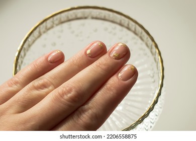 Gentle Aesthetic Trendy Manicure On Short Nails With Transparent Gel Polish With Decor Pieces Of Gold Foil Close-up On Fingernails