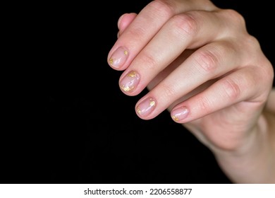 Gentle Aesthetic Trendy Manicure On Short Nails With Transparent Gel Polish With Decor Pieces Of Gold Foil Close-up On Fingernails On A Black Background