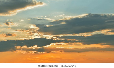 Gentle clouds reflect the sunsetâ€™s magic light, while hidden rays shape a sky full of warmth, color, and softness.