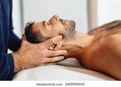 Gentle craniosacral therapy performed by an osteopath, targeting neck pain. - Powered by Shutterstock