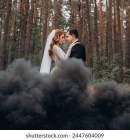 gentle embrace of the bride and groom on the background of black smoke, black smoke. at the wedding.  - Powered by Shutterstock