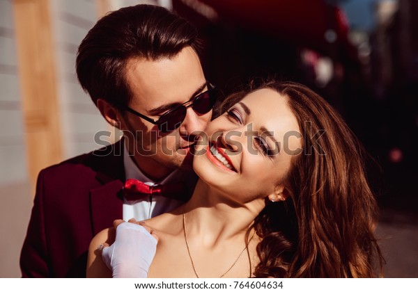 Gentle kiss of a young couple in festive clothing.