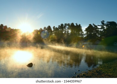 A Gentle Morning On The Lake With Fog Over The Water In The Sun. USA. Maine
