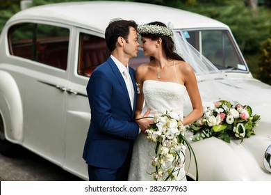 gentle stylish groom and bride on the background old fashioned car