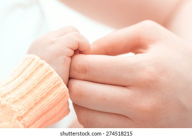 Gentle Touch. Mother Holding Gently The Hand Of Her Baby 