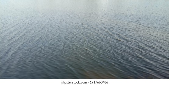 Gentle Water Ripples Of A Lake In A Soft Breeze Morning