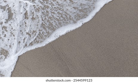 Gentle waves crashing on the beach. The water flows gently to the shoreline and washes away the sand. This beach is located in North Sumatra, Indonesia. - Powered by Shutterstock