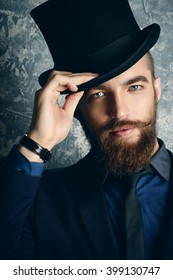 Gentleman with beard and mustache wearing elegant suit and top hat. Old style fashion. 