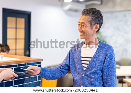 A gentleman makes an electronic payment at a restaurant