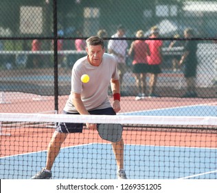 A Gentleman Playing In A Seniors Pickleball Tournament Returns A Dink Shot