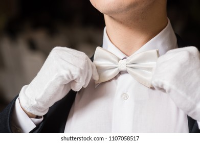 Gentleman touch his white tie bow
