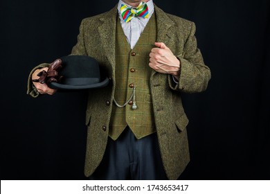 Gentleman In Tweed Suit Holding Bowler Hat On Black Background. Concept Of Classic And Eccentric British Gentleman Stereotype. Retro Style And Fashion.