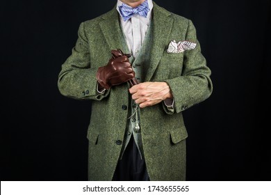 Gentleman In Tweed Suit Holding Leather Gloves On Black Background. Concept Of Classic And Eccentric British Gentleman Stereotype