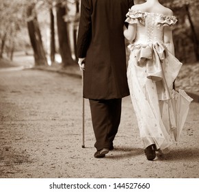 Gentlemen and ladies go through the park. - Shutterstock ID 144527660