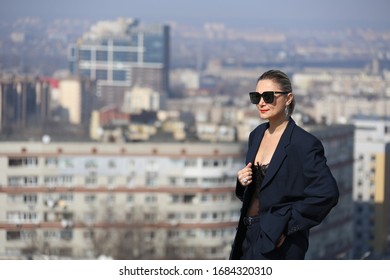 gentlewoman, glamorous portrait of a woman in a man's suit in sunglasses on the roof over the city on a clear day - Shutterstock ID 1684320310