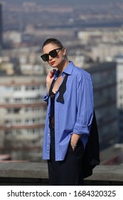 gentlewoman, glamorous portrait of a woman in a man's suit in sunglasses on the roof over the city on a clear day - Shutterstock ID 1684320325