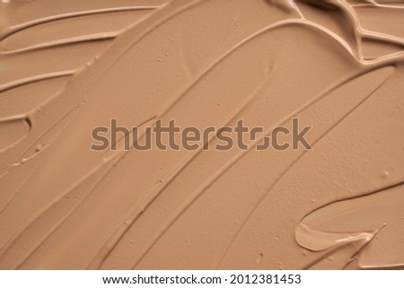Gently beige strokes and texture of makeup foundation or acrylic paint isolated on white background