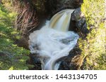 Gently flowing waterfall lined with trees in Northern Minnesota at Cascade River State Park.