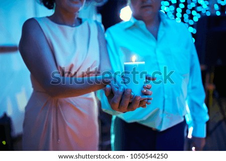 Gently hold a candle at the wedding