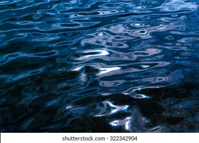 Gently Lapping Waves Form Ripples On The Surface Of Dark Blue Water