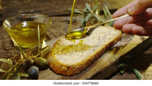 Genuine Italian organic oil cold pressed in slow motion falls on organic bread. concept of nature and healthy food, healthy and natural. fresh olives and Tuscan Italian oil