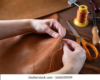 Genuine Leather. Sewing a purse. Leather work. Tools for sewing bags, wallets, clutches. Stitching. Manual sewing of the product. The manufacture of leather products. 