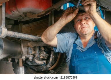 Genuine Truck Repair Worker Repairs Machinery. Portrait Of Auto Mechanic At Work. Truck Suspension Repair. Real Scene.