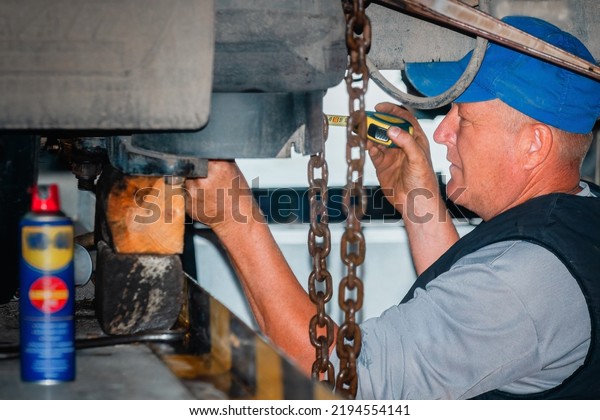 Genuine truck\
repair worker repairs machinery. Portrait of auto mechanic at work.\
Truck suspension repair. Real\
scene.