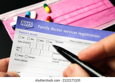 Genuine UK NHS Family Doctor Services Registration Form And Patient Filling It. GMS1 Form With PATIENTS DETAILS. United Kingdom, Stafford, December 18, 2021.