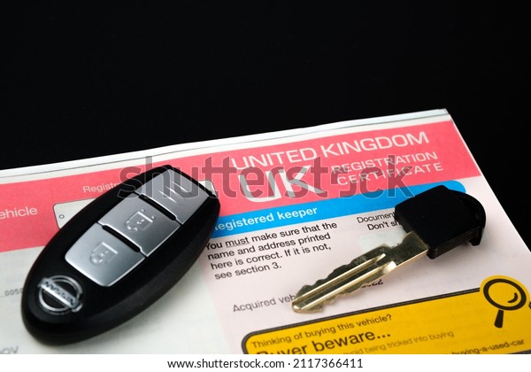 Genuine UK\
registration certificate for a purchased car and car key seen on\
photo. Registration document also known as a vehicle log book V5C.\
Stafford, United Kingdom, January 30,\
2022.