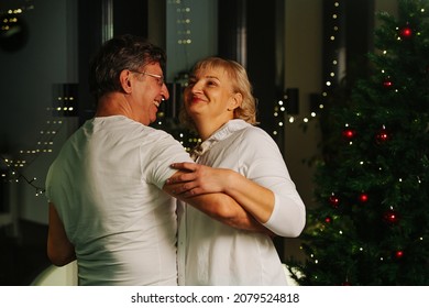 Genuinely Happy Sixty Year Old Couple Dancing Next To A Christmas Tree. Having Fun After A Celebration.