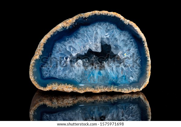Geode with crystals of\
blue color. Quartz geode with transparent crystals on a black\
mirror background.\
