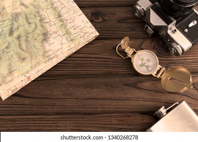 Geographical map, retro camera, compass on a wooden background. travel, tourism, recreation