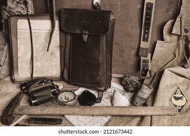 Geological fieldwork tools:map case, geological hammer, compass, magnifying glass, pocket knife, binoculars, storm jacket, drill core, rock samples, topographic and geological maps - Shutterstock ID 2121673442