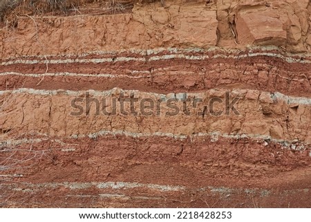 Geological outcrop with layers of earth rock. The texture of the word of soil and clay, which has developed over thousands of years. Archaeological excavations