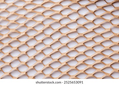 Geometric background with a beige, beige lattice pattern. The background texture is mesh-like, creating a 3D effect. Light brown background. Lattice pattern paper packaging background.