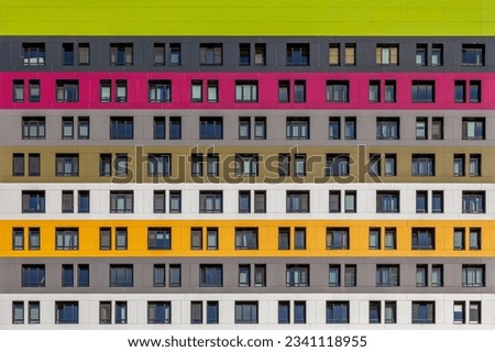 Geometric background from multi-colored rows of windows of a multi-storey building.