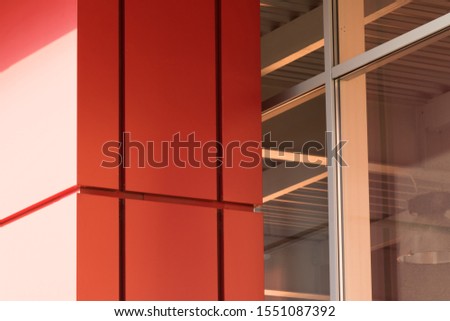 Geometric color elements of the facade of the building with planes, lines, corners with highlights and reflections for the abstract background and texture of red, orange, yellow. Place for text