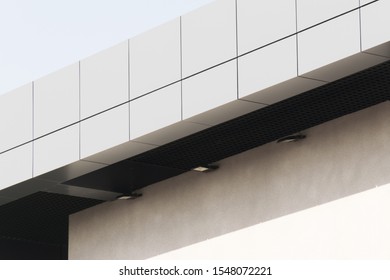 Geometric colored building facade elements with planes, lines and corners with light flare and reflections for an abstract background and texture of white, blue, gray colors. Place for text