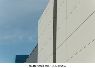 Geometric colored building facade elements with planes, lines and corners with light flare and reflections for an abstract background and texture of white, blue, gray colors. Place for text