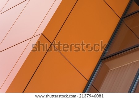 Geometric colored building facade elements with planes, lines and corners with light flare and reflections for an abstract background and texture of white, orange, gray colors. Place for text