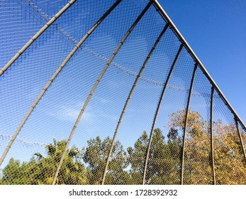 Geometric design element chain link baseball backstop fence and blue sky