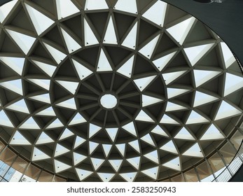 A geometric dome structure with a repeating triangular pattern of skylights, creating a modern and symmetrical design.