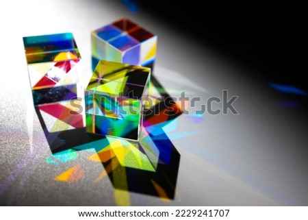 Geometric figure prisms with light diffraction of spectrum and hard shadow on white background