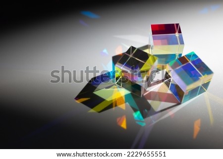 Geometric figure prisms with light diffraction of spectrum and hard shadow on white background