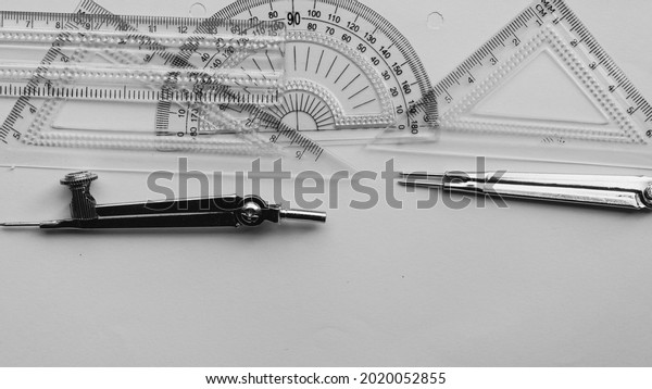 Geometric Measuring tools, Drawing items and
mathematical instruments placed on white paper sheet. Back to
school and Engineering education learning background. Empty Copy
space room for text.