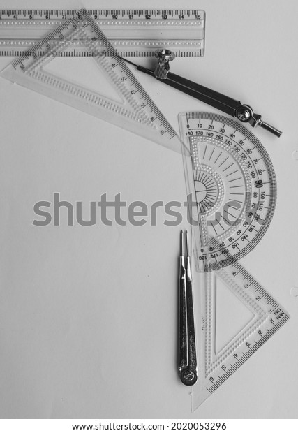 Geometric Measuring tools, Drawing items and\
mathematical instruments placed on white paper sheet. Back to\
school and Engineering education learning background. Empty Copy\
space room for text.