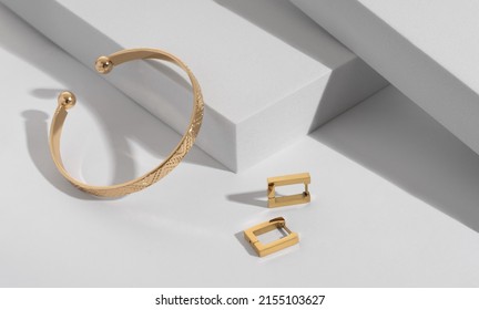 Geometric modern bracelet and earrings pair on white geometric background 