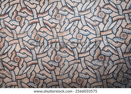Geometric mosaic pattern in Ravenna with interlocking shapes and earthy tones, showcasing Byzantine art. Horizontal image.