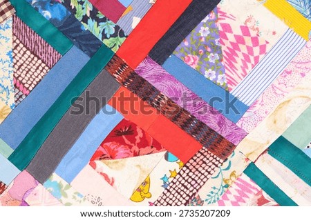 Geometric patchwork texture with bright red and blue fabric accents